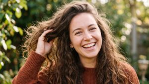Mujer con cabello suave y brillante aplicando una rutina para eliminar el frizz