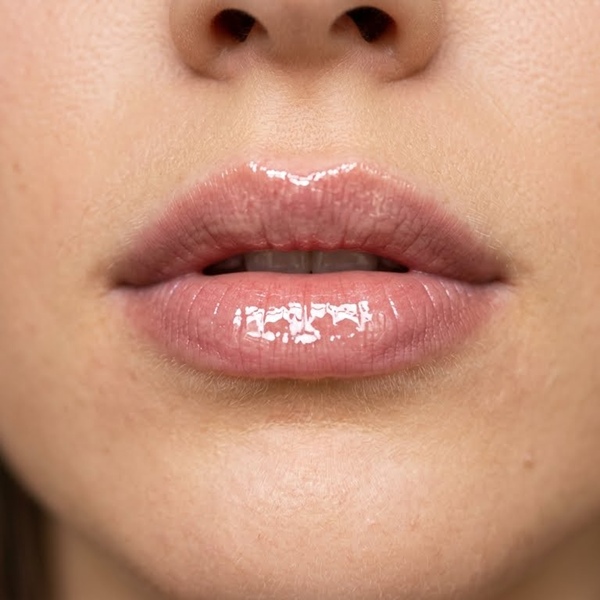 Gloss transparente en el centro de los labios para efecto volumen