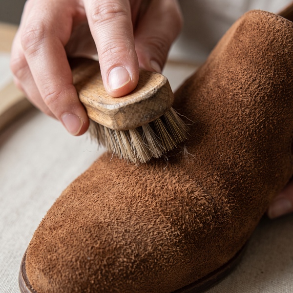 Cepillado suave de un zapato café para recuperar la textura aterciopelada de la gamuza